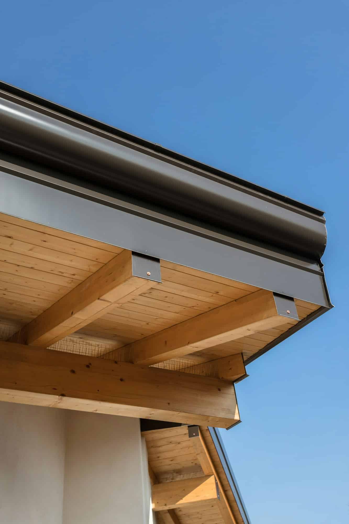New wooden warm ecological house roof with steel gutter rain system